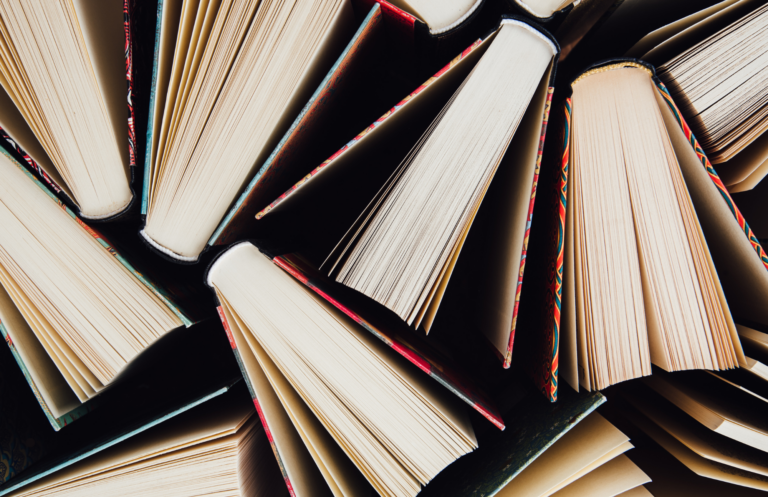 A top view of colorful hard covered books slightly fanned out